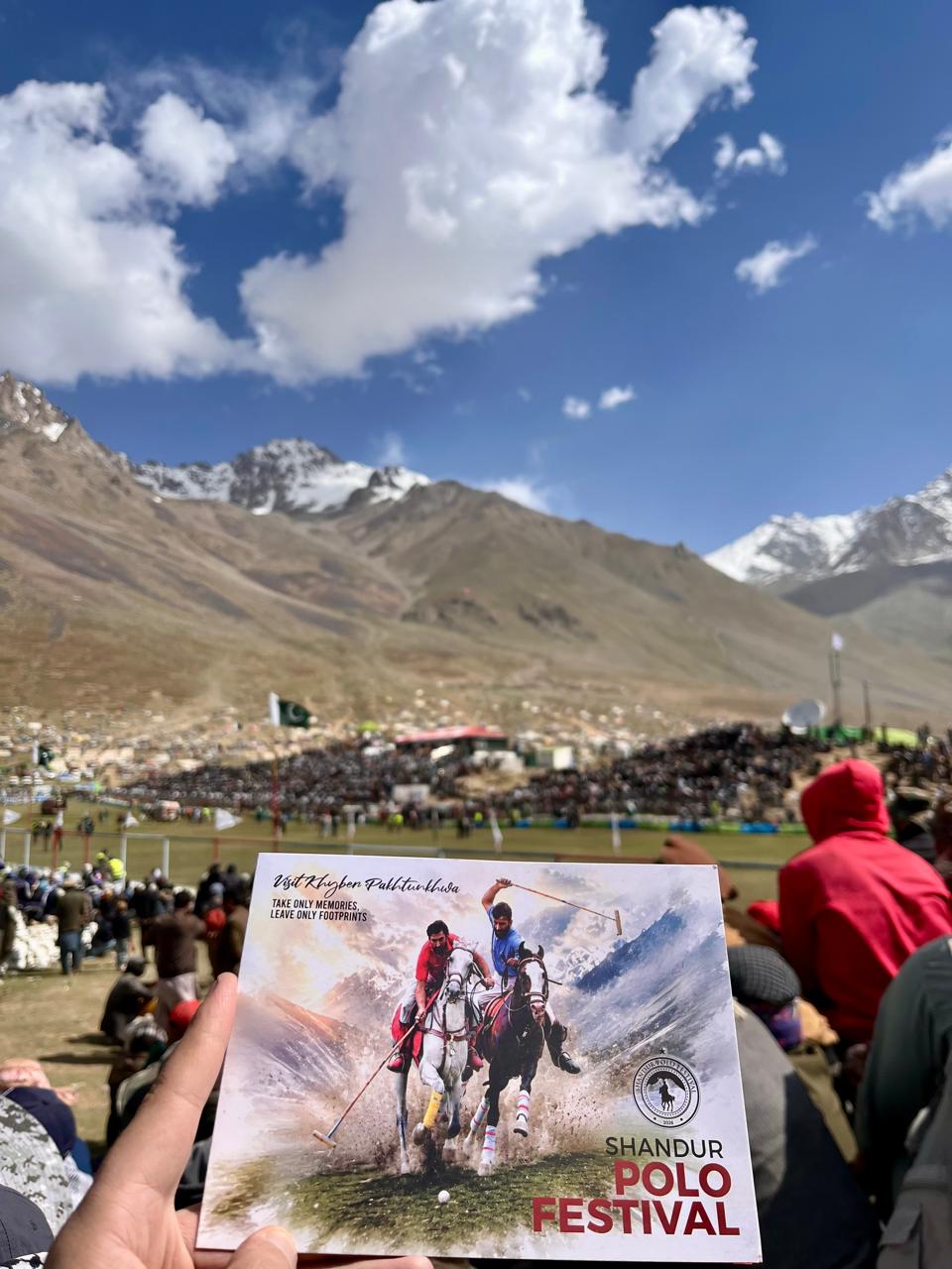 Spectators at the Shandoor Polo Festival with snow-capped peaks behind