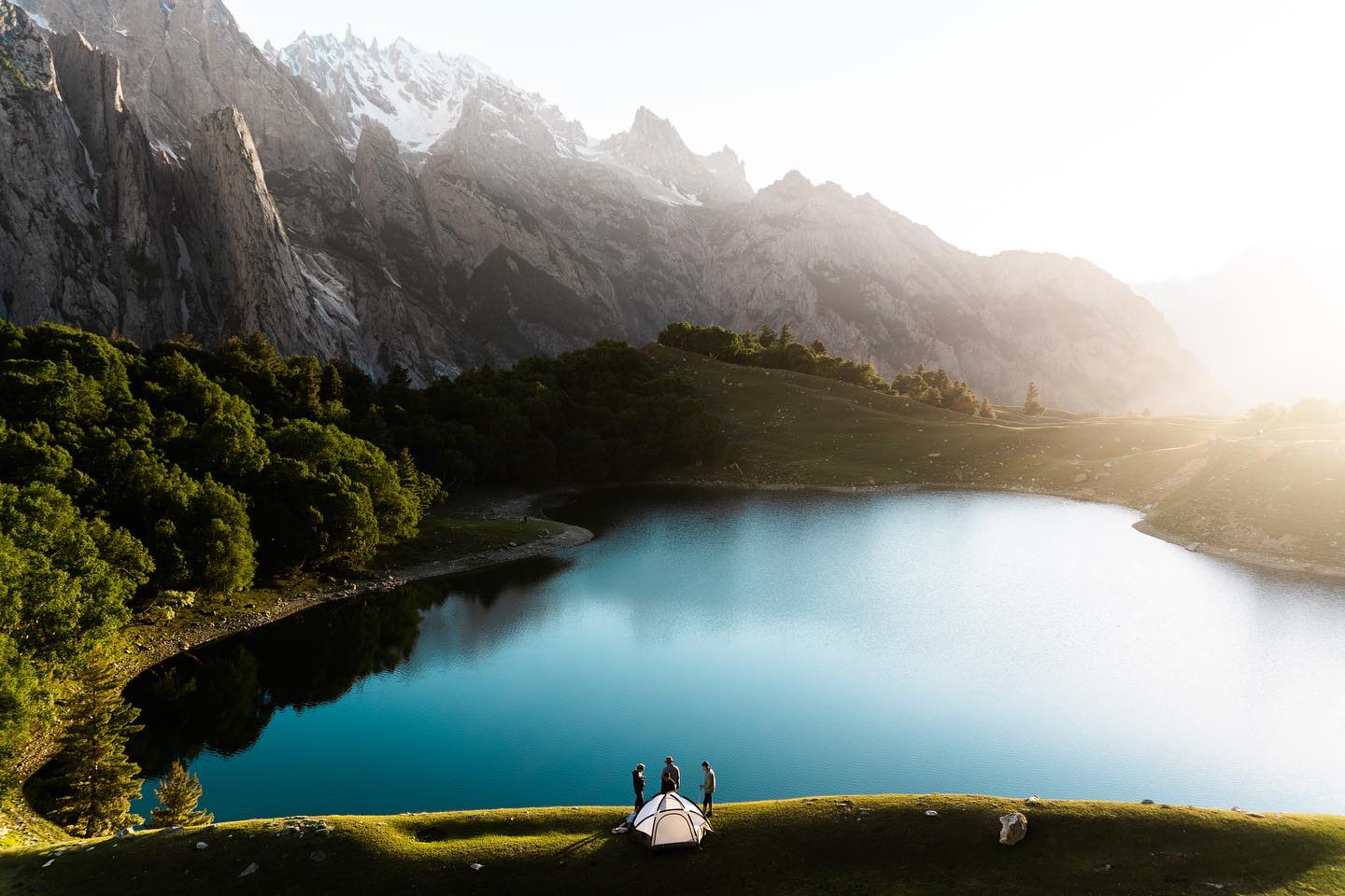 Campers beside the turquoise Kutwal Lake beneath the Haramosh massif at sunrise